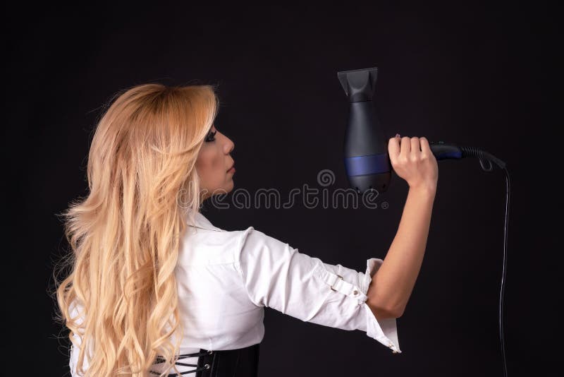 Mão feminina segurando secador de cabelo profissional isolado no