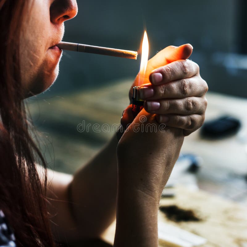 Uma mulher caucasiano está fumando um cigarro imagens de stock royalty free Uma mulher caucasiano está fumando um cigarro imagens de stock royalty free