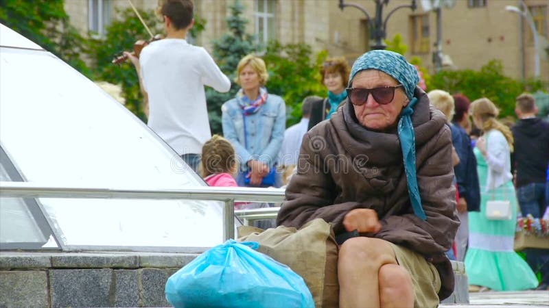 Uma mulher desabrigada bêbado está sentando-se na rua, ondulada acima video estoque