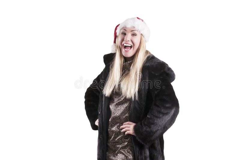 Uma mulher em um casaco de pele, vestindo um chapéu de Santa Claus imagem de stock royalty free Uma mulher em um casaco de pele, vestindo um chapéu de Santa Claus imagem de stock royalty free