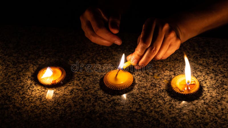 Uma mulher está iluminando três velas denominadas tailandesas durante o festival de Loy Krathong ou de Yeepeng em Chiang Mai foto de stock royalty free Uma mulher está iluminando três velas denominadas tailandesas durante o festival de Loy Krathong ou de Yeepeng em Chiang Mai foto de stock royalty free