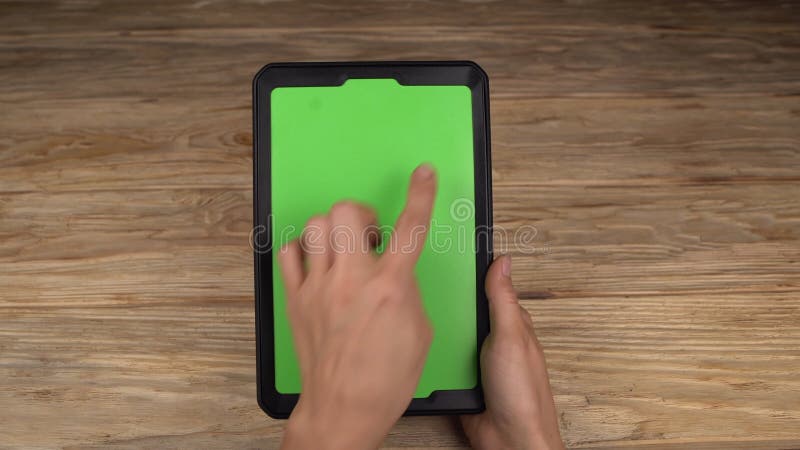 Uma mulher guarda um PC da tabuleta com uma tela verde para seu próprio índice feito sob encomenda