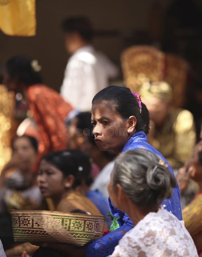 Uma mulher idosa do Balinese na roupa tradicional na cerimônia do templo hindu, ilha de Bali, Indonésia fotos de stock Uma mulher idosa do Balinese na roupa tradicional na cerimônia do templo hindu, ilha de Bali, Indonésia fotos de stock