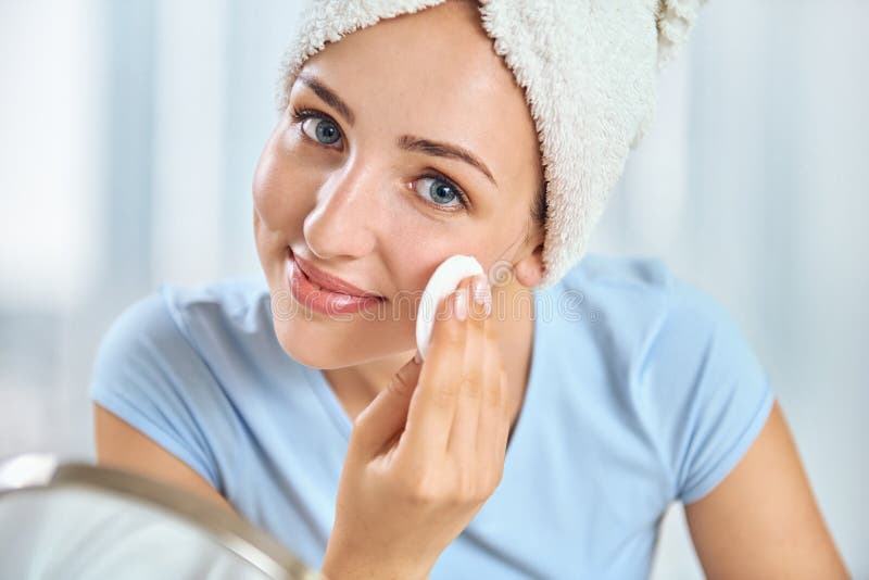 Uma mulher moreno nova com uma toalha envolveu em volta de seu holdi principal fotografia de stock Uma mulher moreno nova com uma toalha envolveu em volta de seu holdi principal fotografia de stock
