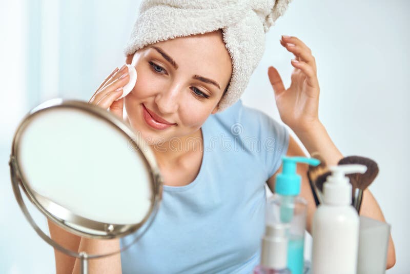 Uma mulher moreno nova com uma toalha envolveu em volta de seu holdi principal imagens de stock Uma mulher moreno nova com uma toalha envolveu em volta de seu holdi principal imagens de stock