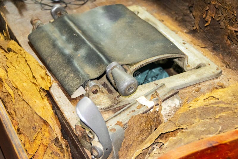 Uma máquina de rolamento do charuto dentro de uma fábrica do charuto Fabricação tradicional de charutos na fábrica do cigarro Faz fotos de stock Uma máquina de rolamento do charuto dentro de uma fábrica do charuto Fabricação tradicional de charutos na fábrica do cigarro Faz fotos de stock