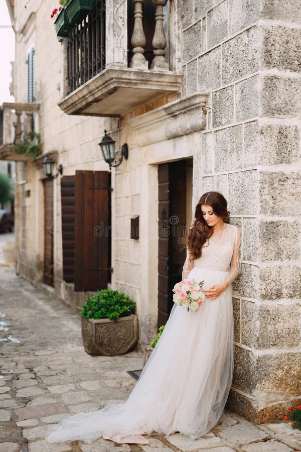 Noiva Com Um Vestido De Noiva E Um Véu Com Um Buquê Caminha Pelo Antigo  Terraço Com Colunas. Lago Como Foto de Stock - Imagem de ternura, casamento:  217945354