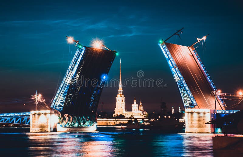 Uma ponte levadiça de St Petersburg na noite e de fortaleza entre ela