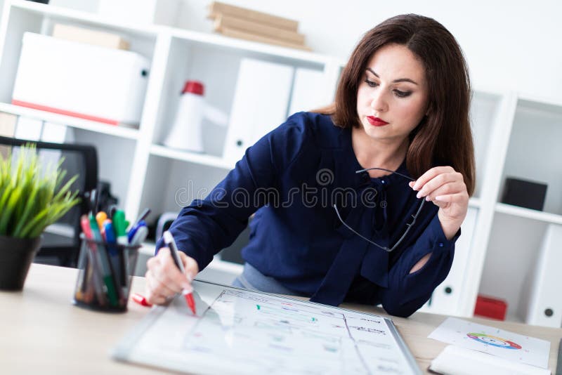 Uma posição da moça em uma tabela do computador e trabalho com uma placa magnética imagens de stock Uma posição da moça em uma tabela do computador e trabalho com uma placa magnética imagens de stock