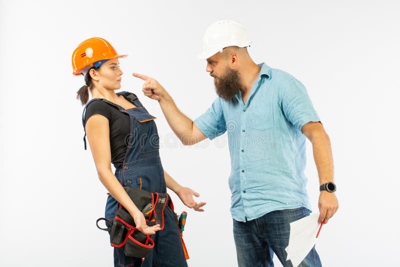 Uma reunião masculina do arquiteto ou do coordenador com um contratante da mulher da construção no fundo branco imagens de stock royalty free Uma reunião masculina do arquiteto ou do coordenador com um contratante da mulher da construção no fundo branco imagens de stock royalty free