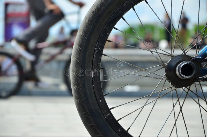 Uma roda da bicicleta de BMX contra o contexto de uma rua borrada com c fotografia de stock