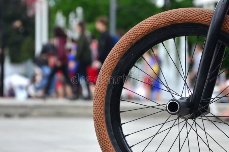 Uma roda da bicicleta de BMX contra o contexto de uma rua borrada com c foto de stock