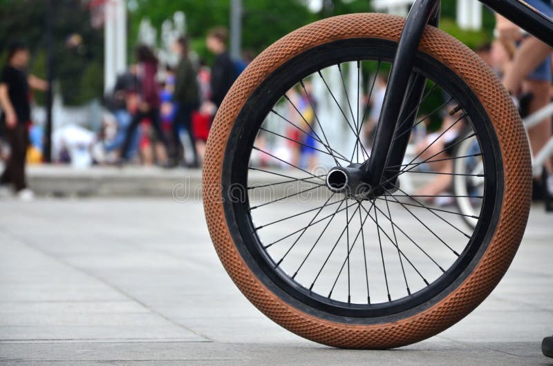 Uma roda da bicicleta de BMX contra o contexto de uma rua borrada com c foto de stock