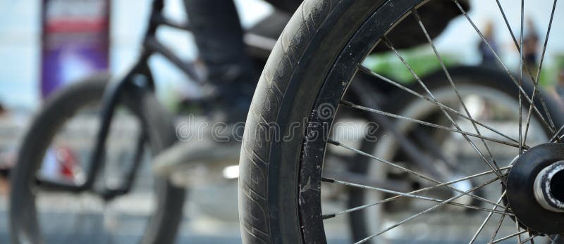 Uma roda da bicicleta de BMX contra o contexto de uma rua borrada com c imagem de stock