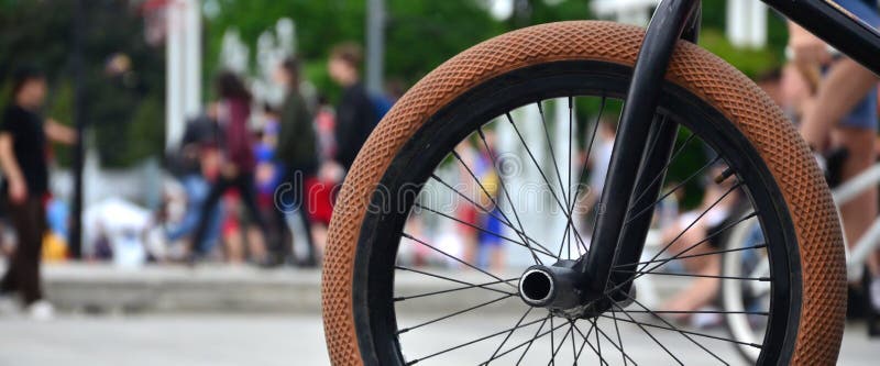 Uma roda da bicicleta de BMX contra o contexto de uma rua borrada com c imagem de stock