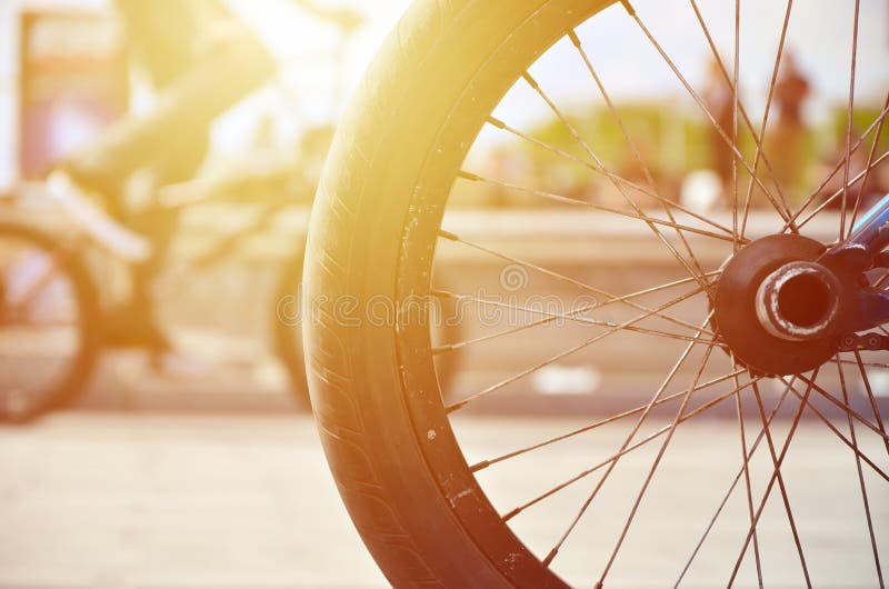 Uma roda da bicicleta de BMX contra o contexto de uma rua borrada com c foto de stock