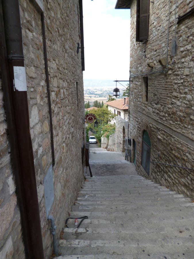 Uma velha rua estreita na cidade medieval de Assisi Itália, agosto de 2012 imagens de stock royalty free Uma velha rua estreita na cidade medieval de Assisi Itália, agosto de 2012 imagens de stock royalty free