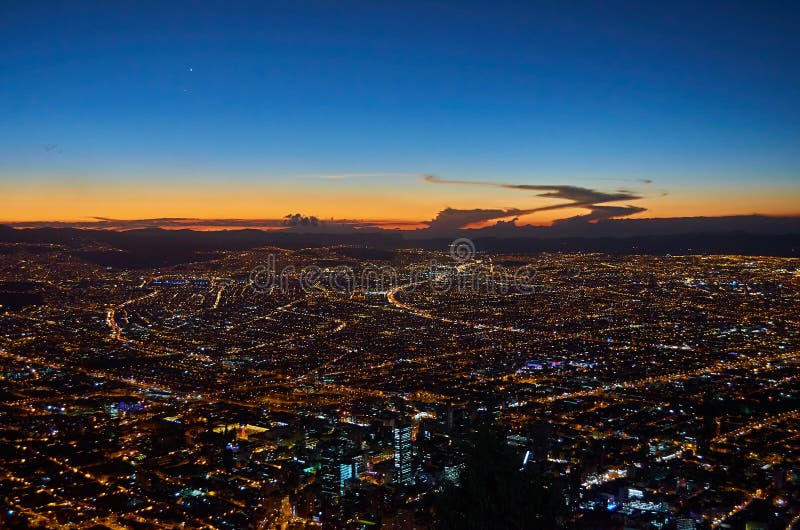 View of the city of Bogota from the Monserrate hill at dusk, with a beautiful horizon with vibrant blue and orange colours. View of the city of Bogota from the Monserrate hill at dusk, with a beautiful horizon with vibrant blue and orange colours