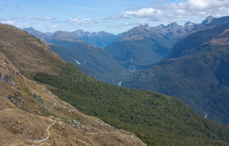 Uma vista em montes e em montanhas do monte cônico em Harris Saddle na grande caminhada de Routeburn, Nova Zelândia foto de stock royalty free Uma vista em montes e em montanhas do monte cônico em Harris Saddle na grande caminhada de Routeburn, Nova Zelândia foto de stock royalty free