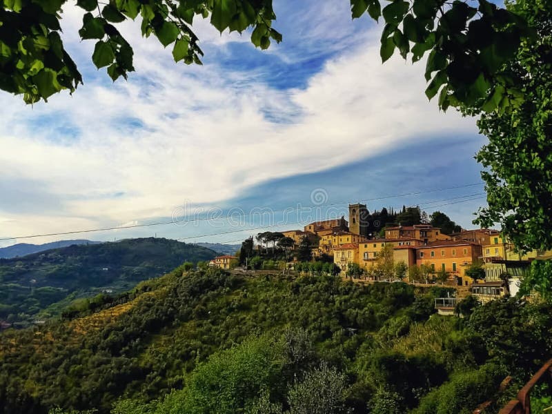 Uma vista panorâmica de uma vila medieval e de montes em Toscânia imagem de stock royalty free Uma vista panorâmica de uma vila medieval e de montes em Toscânia imagem de stock royalty free