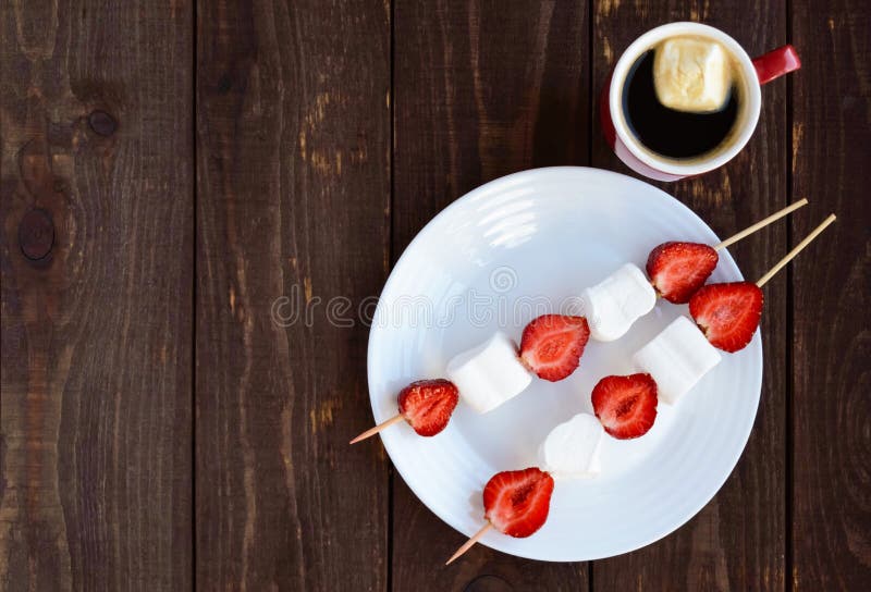 Uma Xícara De Café E Marshmallows Com As Morangos Frescas Em Espetos Foto  de Stock - Imagem de sobremesa, quente: 72783746