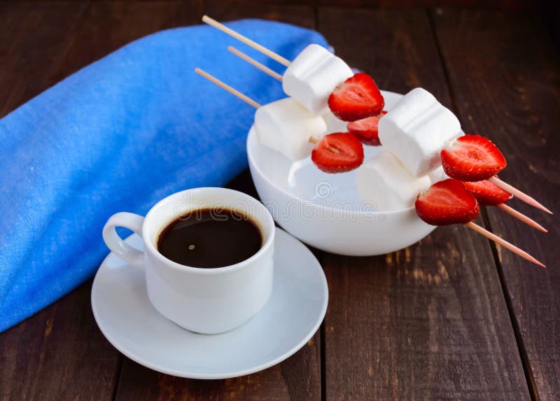 Uma Xícara De Café E Marshmallows Com As Morangos Frescas Em Espetos Foto  de Stock - Imagem de sobremesa, quente: 72783746