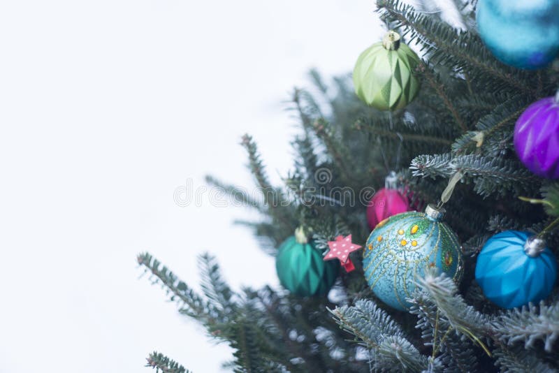 Uma árvore de Natal decorada fora com as bolas brilhantes azuis e roxas imagem de stock royalty free Uma árvore de Natal decorada fora com as bolas brilhantes azuis e roxas imagem de stock royalty free