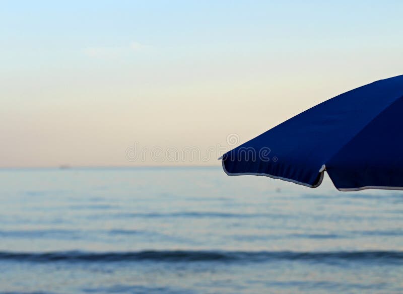 Umbrella at the Beach without Anyone at Sunset on Vacation Stock Image