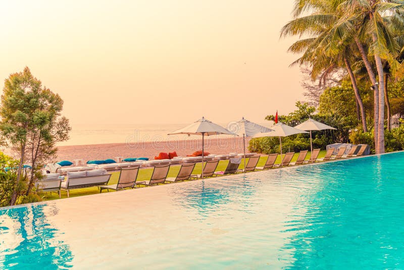 Umbrella and chair around swimming pool with sea ocean view