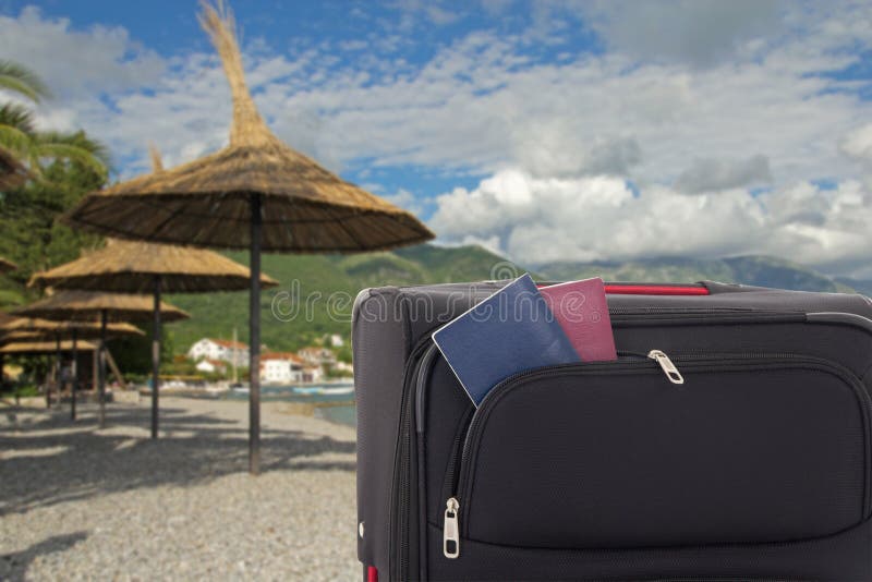 Umbrellas and Suitcase with Passports on the Beach Stock Photo Image