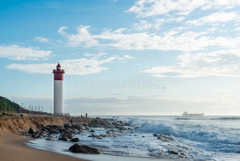 Umhlanga трясет маяк при рыболовы и люди идя на прогулку Корабль на Индийском океане на заднем плане стоковая фотография Umhlanga трясет маяк при рыболовы и люди идя на прогулку Корабль на Индийском океане на заднем плане стоковая фотография
