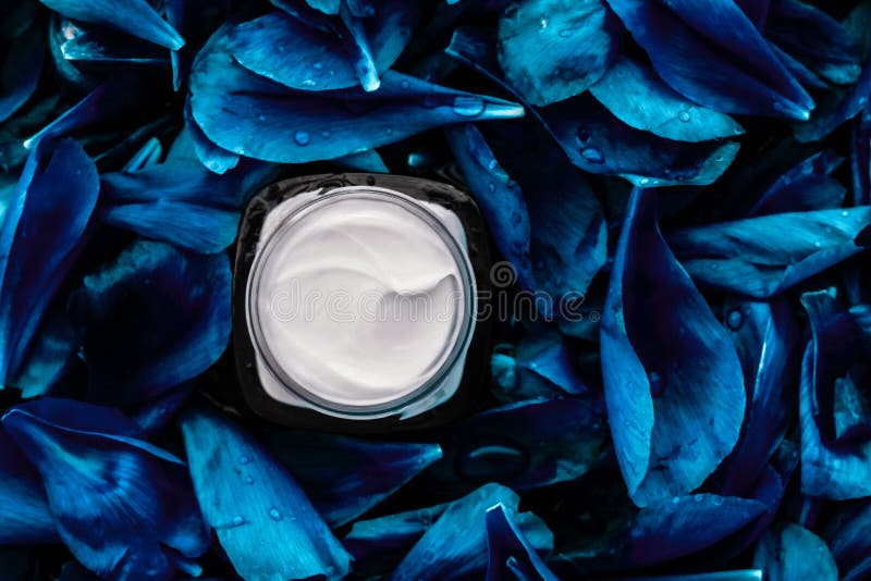 Umidificatore per crema di lusso per la pelle del volto su fondo di fiore blu, essenza floreale, cosmetici spa e emulsione di bel immagini stock Umidificatore per crema di lusso per la pelle del volto su fondo di fiore blu, essenza floreale, cosmetici spa e emulsione di bel immagini stock