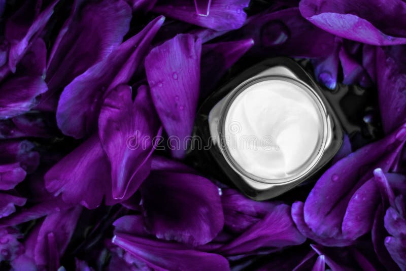 Umidificatore per crema di lusso per la pelle del volto su fondo di fiore viola, essenza floreale, cosmetici spa e emulsione di b fotografia stock libera da diritti Umidificatore per crema di lusso per la pelle del volto su fondo di fiore viola, essenza floreale, cosmetici spa e emulsione di b fotografia stock libera da diritti