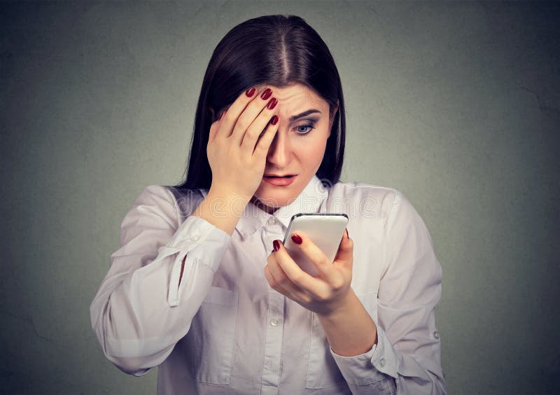 Umkippen entsetzte die ernste Frau, die ihren Handy betrachtet lizenzfreies stockfoto Umkippen entsetzte die ernste Frau, die ihren Handy betrachtet lizenzfreies stockfoto