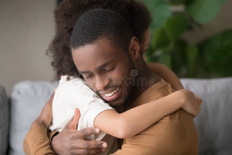 Un abbraccio di papà nero e di figlia che mostrano amore