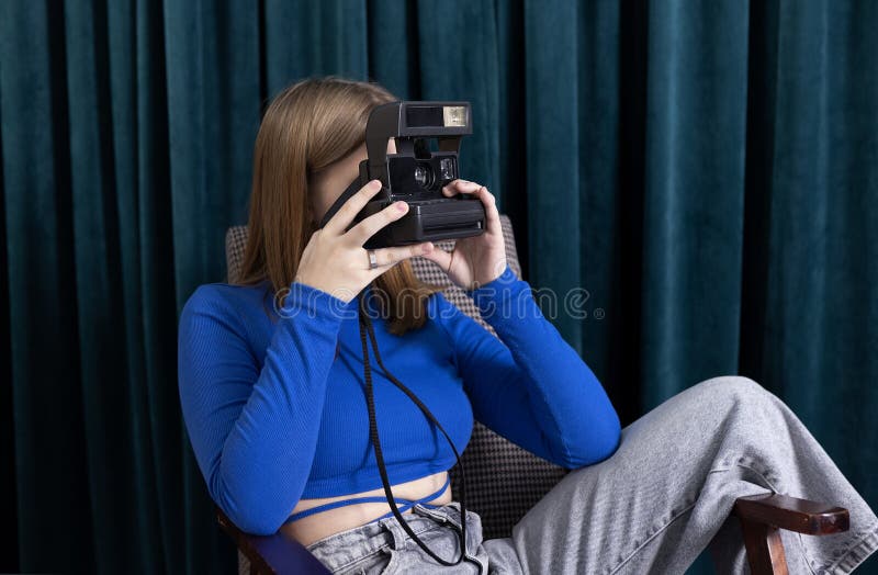 Un adolescente carino in abiti casuali scatta delle foto sedute sul tappeto immagini stock libere da diritti