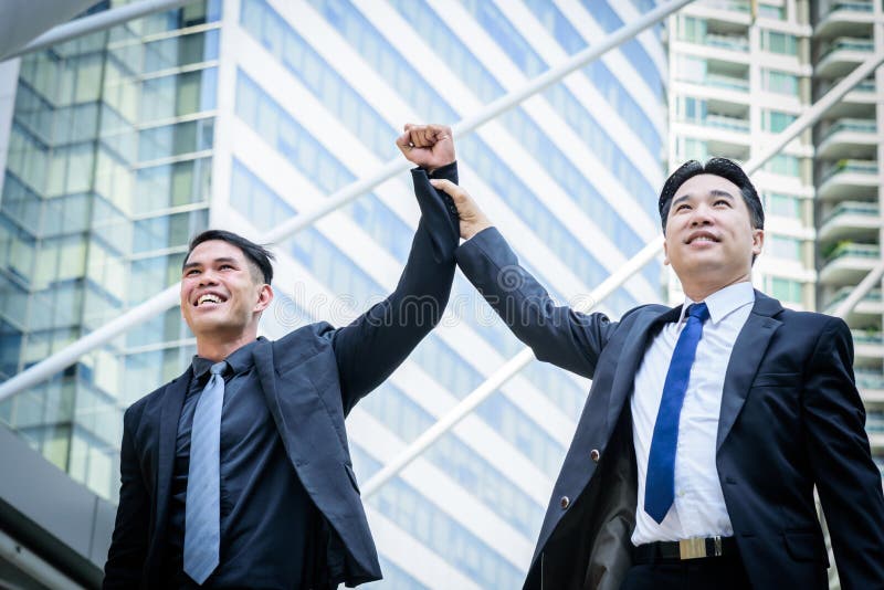 Un affare di due asiatici ha vittoria dello scopo di affari con la costruzione della a immagine stock Un affare di due asiatici ha vittoria dello scopo di affari con la costruzione della a immagine stock