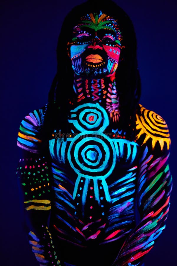 Jeune homme peint à la peinture fluorescente sur le visage et le torse  musclé, dans le studio photo grâce à la lumière UV Photo Stock - Alamy