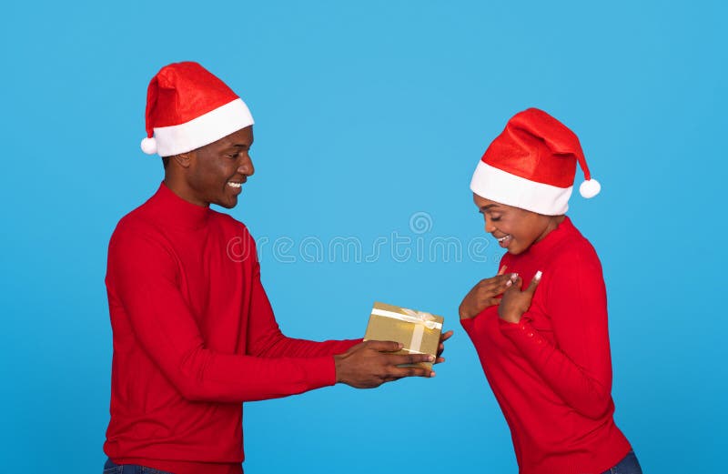 Un Homme Présentant Un Cadeau De Noël à Sa Petite Amie Image stock