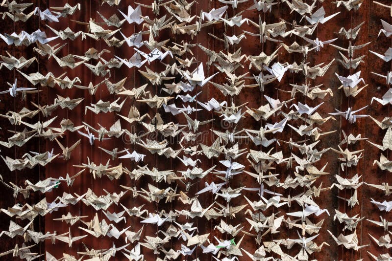 Un ampio dettaglio di 1000 origami ha piegato la scultura di carta delle gru contro un fondo rosso-cupo immagine stock libera da diritti Un ampio dettaglio di 1000 origami ha piegato la scultura di carta delle gru contro un fondo rosso-cupo immagine stock libera da diritti
