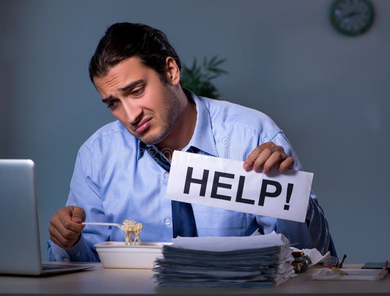 Un angajat înfometat care lucrează până târziu în birou royalty free stock photography