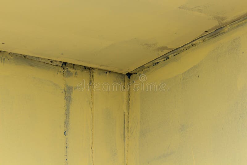 Un angolo del ferro alla giunzione delle pareti con le cuciture di un colore incomprensibile immagini stock Un angolo del ferro alla giunzione delle pareti con le cuciture di un colore incomprensibile immagini stock
