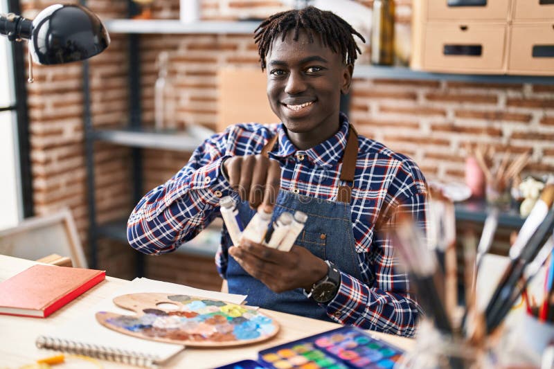 Un artist american care zâmbește încrezător alegând culori în studio stock images