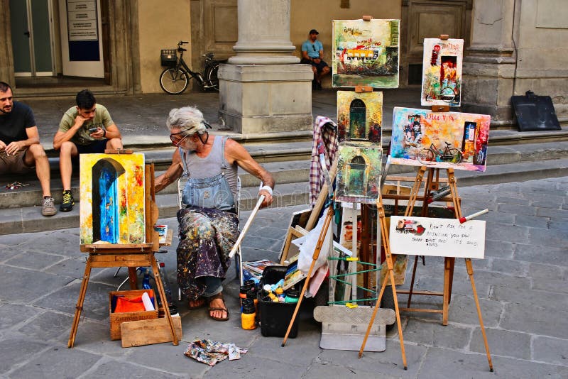 Un artista che vende opere d'arte per la strada a Firenze fotografie stock libere da diritti Un artista che vende opere d'arte per la strada a Firenze fotografie stock libere da diritti
