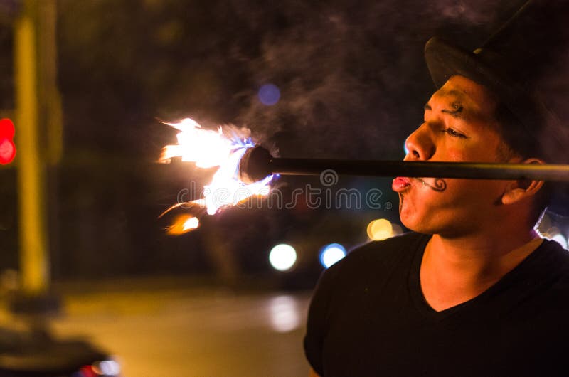 Un artista de la calle que hace una demostración en Lima - Perú, haciendo juegos malabares un palillo con el fuego en las parad fotos de archivo Un artista de la calle que hace una demostración en Lima - Perú, haciendo juegos malabares un palillo con el fuego en las parad fotos de archivo