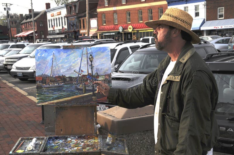 Un artista della via dipinge un'immagine immagine stock Un artista della via dipinge un'immagine immagine stock