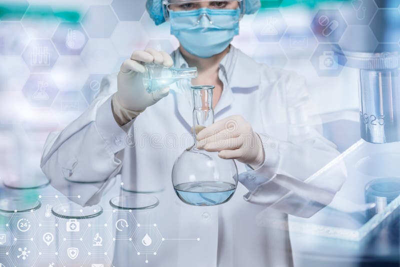 Un assistant laboratorian verse une certaine substance liquide de tube dans un flacon photos libres de droits Un assistant laboratorian verse une certaine substance liquide de tube dans un flacon photos libres de droits