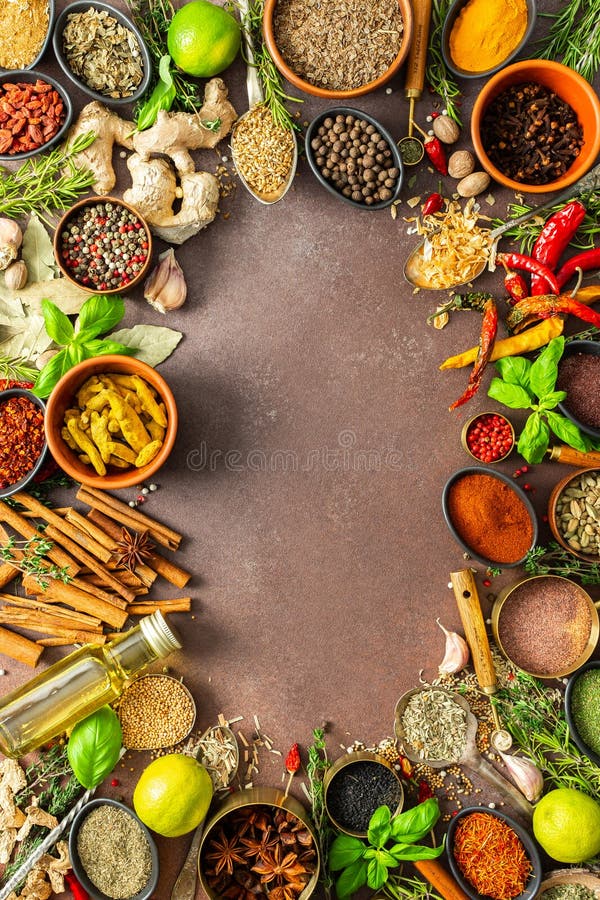 Un assortimento colorato di erbe aromatiche e spezie su uno sfondo marrone caldo che mostra la loro varietà visiva e fotografia stock
