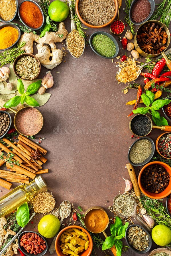 Un assortimento colorato di erbe aromatiche e spezie su uno sfondo marrone caldo che mostra la loro varietà visiva e fotografie stock