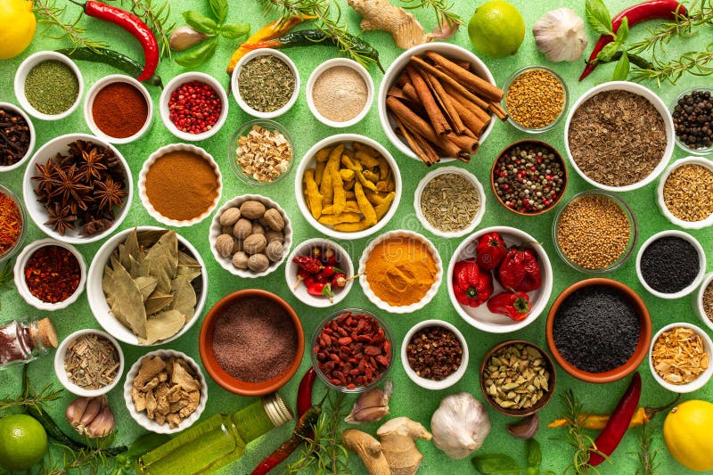 Un assortimento colorato di spezie e erbe fragranti fresche riprodotte su uno sfondo verde morbido che cattura un vibrante fotografia stock libera da diritti